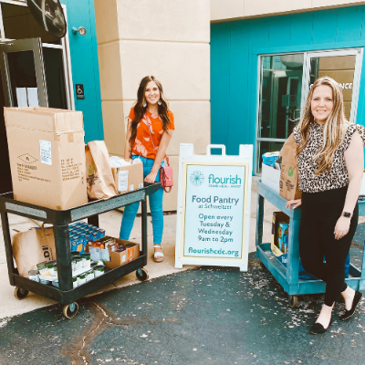 OakStar employees pose for a picture in-front of a Food Pantry while donating goods